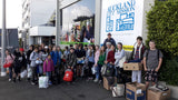 A row of children with donations outside Auckland City Mission